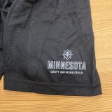 Close-up of black t-shirt sleeve with gray Minnesota Craft Brewers Guild logo in light gray
